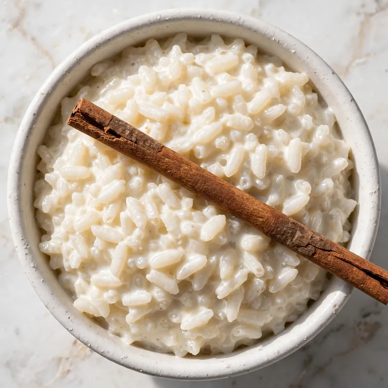 Two bowls of arroz con leche with cinnamon dusting overhead view